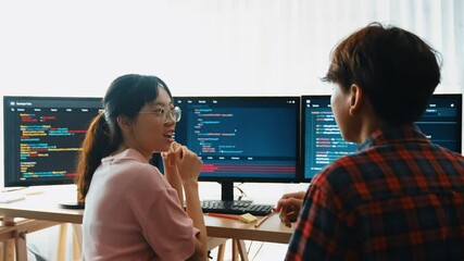 Slow motion back end software developer engineer for computer programming working together on debugging writing computing code, solving complex algorithms display on monitor in office. Burgeoning
