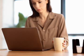 Aufkleber - Serious Female Manager Using Laptop Reading Business News Having Morning Coffee Working From Home