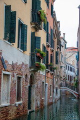 Venice cityscape, narrow water canal, bridge and traditional yellow-orange buildings. Italy, Europe.