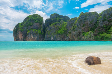 Maya Bay tropical sandy beach with turquoise water in lagoon onsunny day on Phi Phi islands, Krabi, Thailand with nobody. Empty beach with cliff rocks and lush greenery. Travel and tourism in Asia