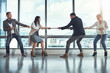 © CamPen2000/peopleimages.com - Tug of war, business and people in office for battle, rivalry and healthy competition for growth. Team building, men and women in corporate workplace with rope, pull and challenge for staff in city