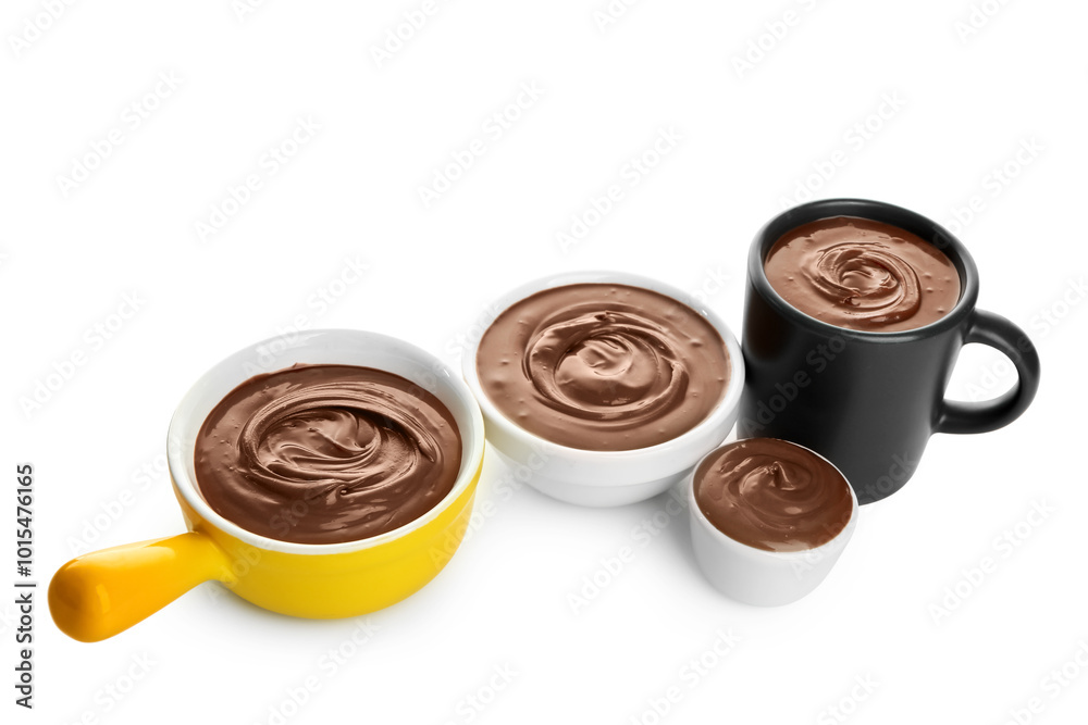 Bowls and cup of tasty melted chocolate on white background