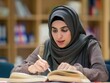 © miss irine - Young woman studies in library surrounded by books. She wears gray hijab, brown scarf, focuses on reading. Rich collection of knowledge. Muslim female student prepares for exams in academic setting.