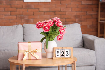 Poster - Vase with flowers, gift box and calendar on coffee table in living room