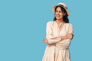 Poster - Pretty African-American woman in dress and hat on blue background