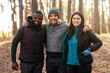 © Prostock-studio - Happy adventurous international friends posing over blue tent in the middle of forest