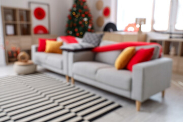 Canvas Print - Blurred view of living room decorated for Japanese New Year celebration with sofas and fir tree