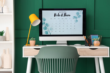 Canvas Print - Computer monitor with Save the Date Announcement on wedding planner's table near green wall in office