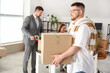 © Pixel-Shot - Businessman carrying box in office on moving day