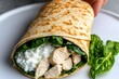 © Sanchai - Person preparing a chicken and spinach wrap with a side of cottage cheese, showcasing a high-protein diet lunch idea