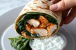 © Sanchai - Person preparing a chicken and spinach wrap with a side of cottage cheese, showcasing a high-protein diet lunch idea