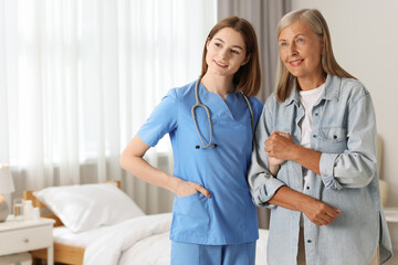 Wall Mural - Smiling healthcare worker supporting senior patient indoors. Space for text