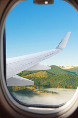 Wall Mural - Airplane flying over mountains, beautiful view from window