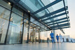 © Artinun - The modern entrance of a city hospital featuring glass doors, a canopy, and healthcare staff entering. A professional and clean architectural design that serves as a vital healthcare facility.