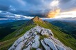 © Thanyarat - Mountain peak at sunset, with dramatic light casting shadows on the rocky cliffs and valleys below