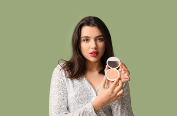 Wall Mural - Beautiful young woman with powder on green background