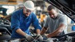 © Old Man Stocker - Two skilled mechanics collaboratively working on an automotive engine in a repair shop, showcasing teamwork and professionalism in the automotive industry.