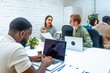 © unai - Multiracial people working using laptop in a coworking