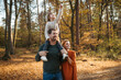© Halfpoint - Young family with small children on walk in autumn forest. Father carrying daughter on his shoulders.