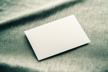 Close-up of empty white business card on textured fabric surface