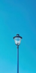 Poster - A blue lamp shining in a blue sky, casting soft, serene light all around. Copy space for text.