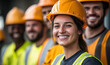 © Miraime - Group of happy builders in hardhats standing together on construction site with PPE.