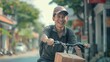 © VK Studio - A cheerful man rides a bicycle with a box, embracing the warmth of a sunlit urban street, exuding joy and freedom.