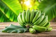 © anulak - Green bananas on top of wooden table with green leaf background