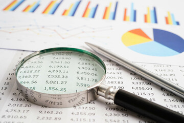 Magnifying glass on spreadsheet and  graph paper. Financial development, Banking Account, Statistic, Investment Analytic research data economy.