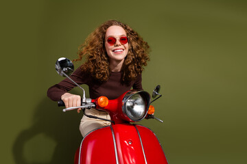 Sticker - Photo of excited attractive young lady dressed brown outfit driving scooter empty space isolated khaki color background