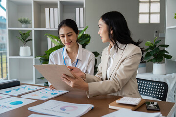 Professional Business Meeting in Modern Office with Two Women collaboration on Financial Reports and Data Analysis