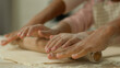 © Yuliia - Close up cropped view hands arms African woman mother female mom teaching little child kid girl daughter cooking pastry pizza baking teach using rolling pin together at kitchen table dough cook pie