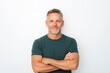 © yj - Happy middle aged man isolated on white studio background. Confident mature mid adult handsome male model wearing t-shirt looking at camera with arms crossed.