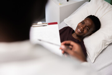 Patient lying down, doctor with papers nearby.