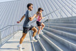 © muse studio - Fitness Enthusiasts Running up Outdoor Stairs During a Sunny Day Workout in a Modern Urban Setting