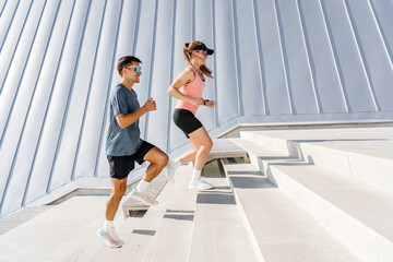 Two Athletes Running up Outdoor Stairs at a Modern Building During Daytime Workout Session