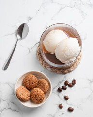 Wall Mural - Affogato coffee with vanilla ice cream scoops and  espresso in a glass on a marble background with coffee beans and cookies.