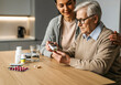 © EvgeniiaFreeman - Senior woman checking blood sugar with caregiver at home