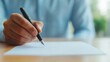 © Intelligent Horizons - Close up view of a person s hand holding a pen over a blank ballot paper or document representing the process of making a voting decision and participating in the democratic process