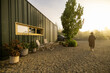 © rh2010 - A person enjoys the peaceful morning light outside a modern cabin, capturing the essence of tranquility and solitude in nature