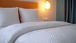 © auc - Cozy white bedding on a comfortable hotel bed with soft pillows.