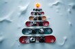 © Yana Gavriloski - A festive display features snowboards arranged like a Christmas tree, with cameras nestled among them, all set against a snowy backdrop and topped with a bright star