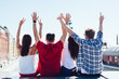 © BullRun - Anonymous friends with raised arms on street