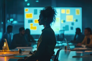 Poster - A woman sitting at a table in front of a projector screen, perfect for presentations, meetings or education.