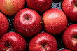 © fahrwasser - Fresh red apples filling the entire frame with droplets of water glistening, food background, overhead shot