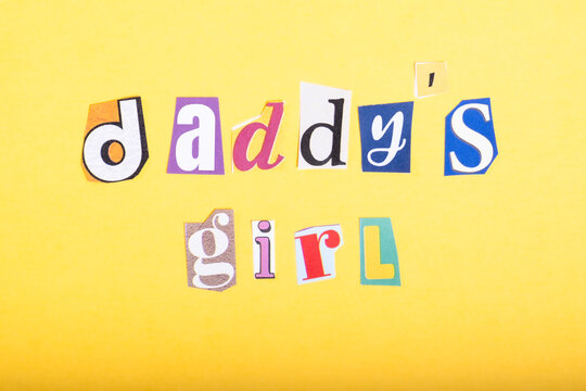 Phrase Daddy's Girl spelled in cut out newspaper style typography, isolated on yellow background.