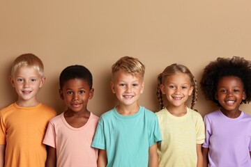 Group of happy children standing together and looking at camera over beige background