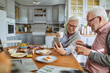 © Marko Geber - Happy senior couple eating breakfast together at kitchen table