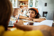 © Davor - Focused woman listening attentively during study session at the kitchen table