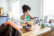 © Davor - Focused woman listening attentively during study session at the kitchen table